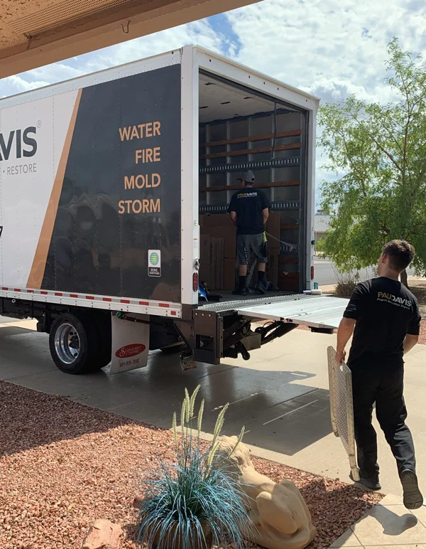A contents crew loading household items beside a Paul Davis restoration truck.
